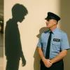 Тень подростка нависает над охранником в торговом центре