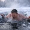 Мужчина ныряет в ледяную воду зимой