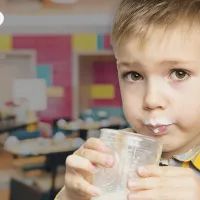 Мальчик пьет молоко