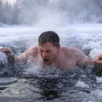 Мужчина ныряет в ледяную воду зимой